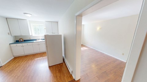 A kitchen with white cabinets and a window.